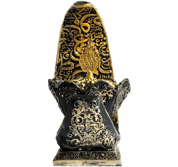 Intricately carved black and gold tribal mask sculpture.